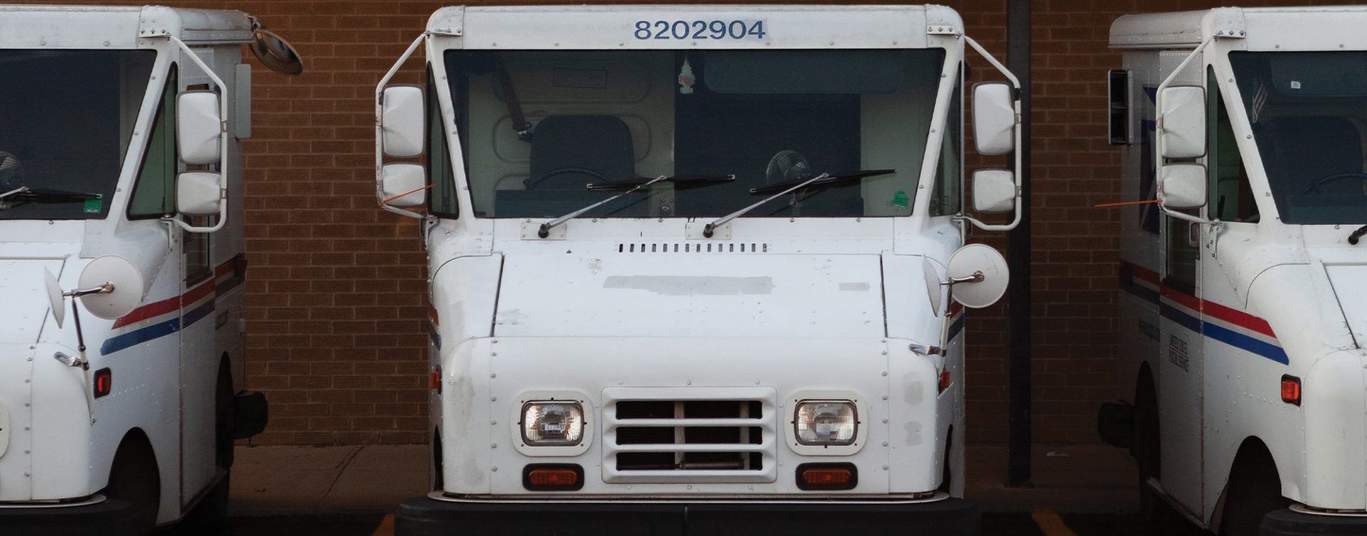 USPS mail trucks parked at a postal facility